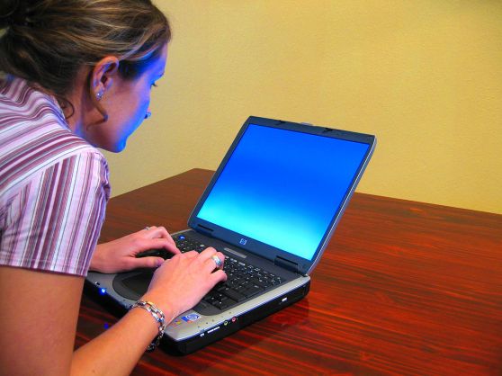 1200px-Woman-typing-on-laptop